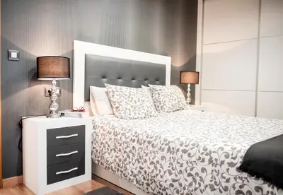 a bedroom with a white bed with a large headboard at Apartamento Cuatro Caminos in Chantada