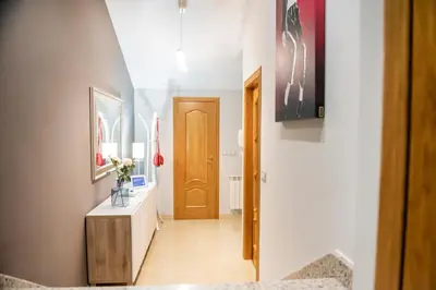 a hallway with a wooden door and a table at Apartamento Cuatro Caminos in Chantada