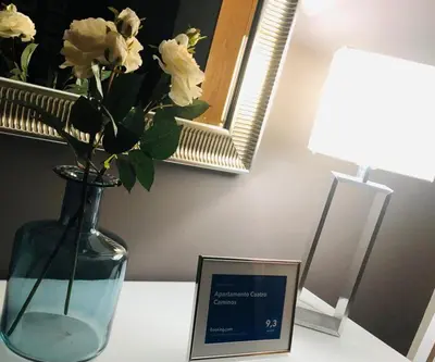 a vase with white flowers and a sign on a table at Apartamento Cuatro Caminos in Chantada