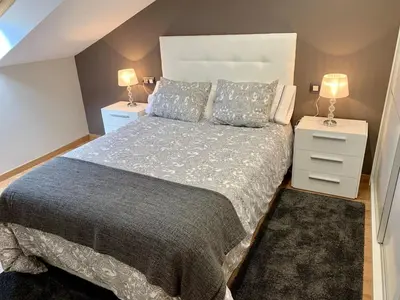 a bedroom with a large bed and two night stands at Apartamento Cuatro Caminos in Chantada