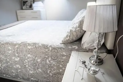 a bed with a table with a lamp on it at Apartamento Cuatro Caminos in Chantada