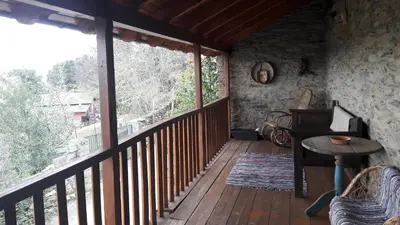 a porch with a wooden deck with a table and a window at Casa rural Albina in Susañe del Sil