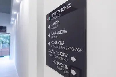 a black sign with arrows on a wall at Dream in Santiago in Santiago de Compostela