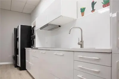 a kitchen with white cabinets and a black refrigerator at Dream in Santiago in Santiago de Compostela