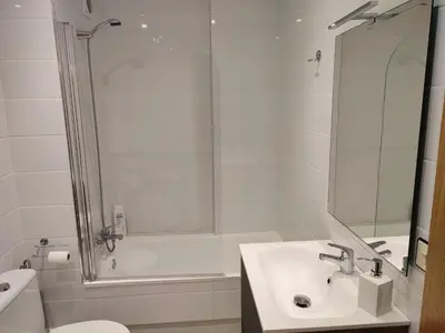 a white bathroom with a sink and a shower at Perla del Cantábrico in Vivero