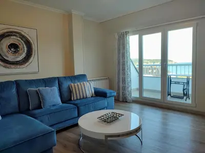 a living room with a blue couch and a table at Perla del Cantábrico in Vivero