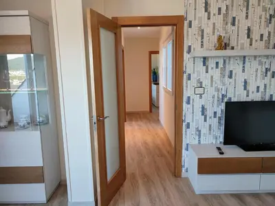 a living room with a television and a hallway at Perla del Cantábrico in Vivero