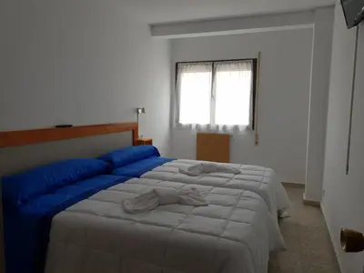 a bedroom with a large bed with blue pillows at Apartamentos O Cargadeiro Ribadeo in Ribadeo