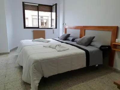 two beds in a bedroom with towels on them at Apartamentos O Cargadeiro Ribadeo in Ribadeo