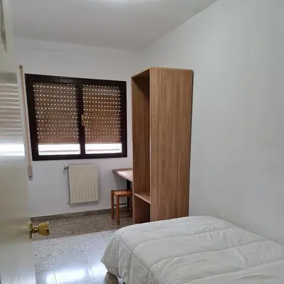 a bedroom with a bed and a window and a desk at Apartamentos O Cargadeiro Ribadeo in Ribadeo