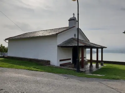 a small white church on the side of a road at Apartamentos O Cargadeiro Ribadeo in Ribadeo