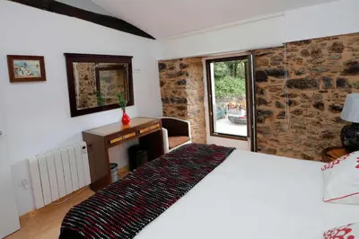 a bedroom with a bed and a desk and a window at Casa Santa María in Melide
