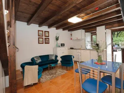 a kitchen and living room with a blue table and chairs at Casa Santa María in Melide