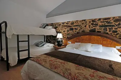 a bedroom with two beds and a loft bed at Casa Santa María in Melide