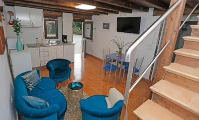 a living room with blue chairs and a kitchen at Casa Santa María in Melide
