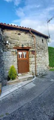 a stone building with a wooden door on it at Casa da Canella - En la Ribeira Sacra in Ourense