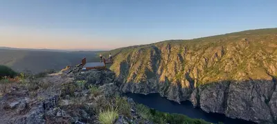 two people standing on a bridge over a river on a cliff at Casa da Canella - En la Ribeira Sacra in Ourense