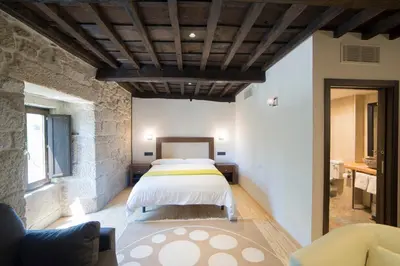 a bedroom with a bed and a couch in a room at Reitoral de Parada in Parada del Sil