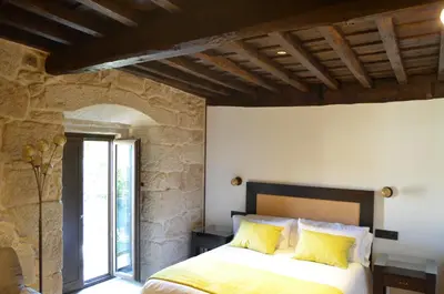 a bedroom with a bed with yellow pillows at Reitoral de Parada in Parada del Sil