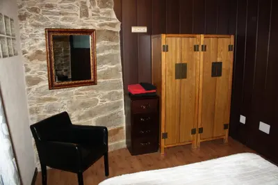 a bedroom with a dresser and a mirror and a chair at Alojamiento Luz de Hadas in Sampil