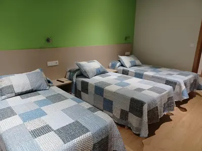 three beds in a room with green walls at Hosteria de Gonzar in Gonzar