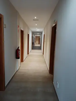a hallway of an office building with a long corridor at Hosteria de Gonzar in Gonzar