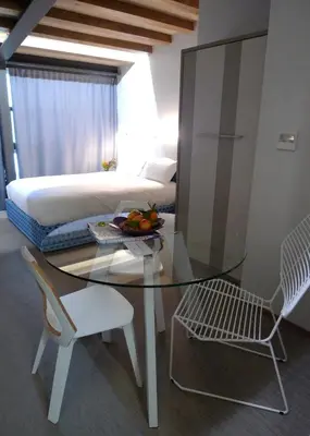 a room with a glass table and a bed at Blanco Apartamentos Turísticos in Santiago de Compostela