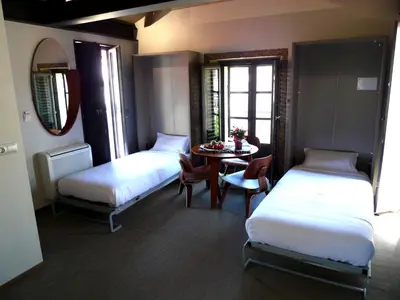 a hotel room with two beds and a table and a tableablish at Blanco Apartamentos Turísticos in Santiago de Compostela