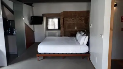 a bedroom with a white bed and a window at Blanco Apartamentos Turísticos in Santiago de Compostela