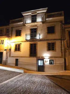 a large white building with two balconies at night at Blanco Apartamentos Turísticos in Santiago de Compostela