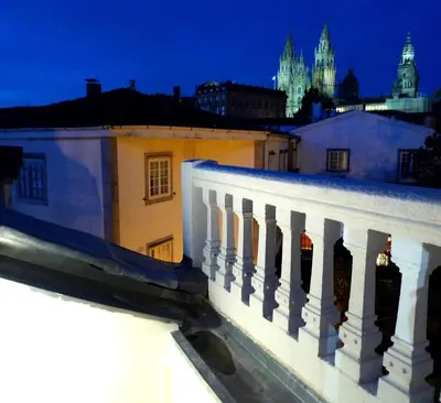 a view of a city at night from a balcony at Blanco Apartamentos Turísticos in Santiago de Compostela