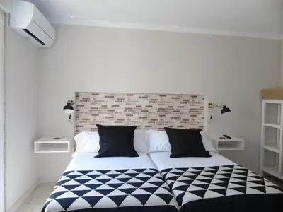 a black and white bed in a white room at Casa San Nicolás in Portomarin