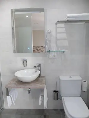 a white bathroom with a sink and a toilet at Casa San Nicolás in Portomarin