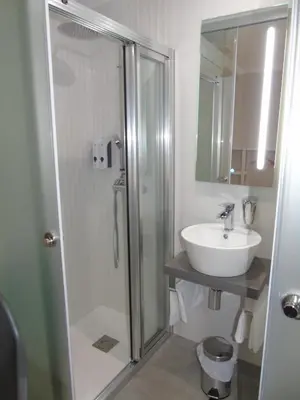 a bathroom with a shower and a white sink at Casa San Nicolás in Portomarin