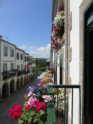 a street with flowers on the side of a building at Casa San Nicolás in Portomarin