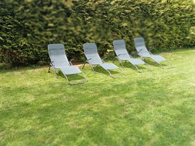 a row of chairs sitting in the grass at Pension Xacobeo Lavacolla in Lavacolla