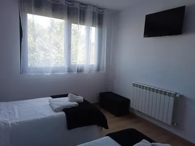 a bedroom with two beds and a window at Pension Xacobeo Lavacolla in Lavacolla