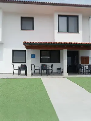 a house with a patio with tables and chairs at Pension Xacobeo Lavacolla in Lavacolla