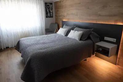 a bedroom with a large bed and a window at Hostal O'Cruceiro in O Pino