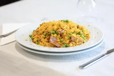 a plate of rice with meat and peas on a table at Hostal O'Cruceiro in O Pino