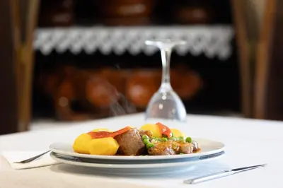 a plate of food on a table with a wine glass at Hostal O'Cruceiro in O Pino