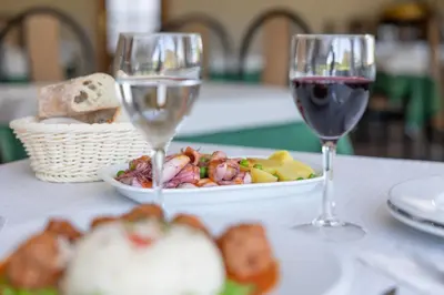 two glasses of wine and a plate of food on a table at Hostal O'Cruceiro in O Pino