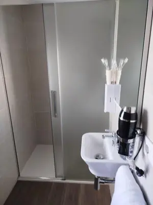 a bathroom with a shower and a white sink at Hotel Canaima Bruma 1,5 k Camino in O Mesón Do Vento