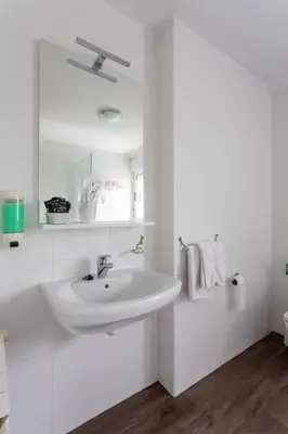 a white bathroom with a sink and a mirror at Hotel Canaima Bruma 1,5 k Camino in O Mesón Do Vento