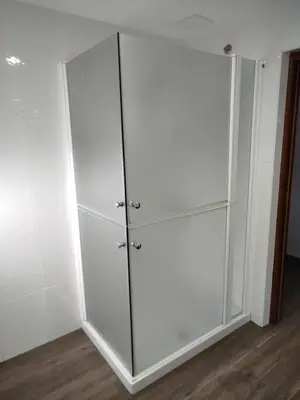 a white closet with glass doors in a room at Hotel Canaima Bruma 1,5 k Camino in O Mesón Do Vento
