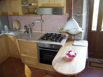 a kitchen with a stove and a wooden table at Torre Tanquián Eco Finca - Ribeira Sacra in Pantón