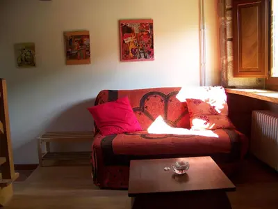 a living room with a couch with red pillows at Torre Tanquián Eco Finca - Ribeira Sacra in Pantón