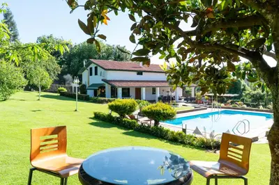 a table and chairs in a yard with a pool at VILLA GUIMIL - GALICIA PLAYA in Villarmayor