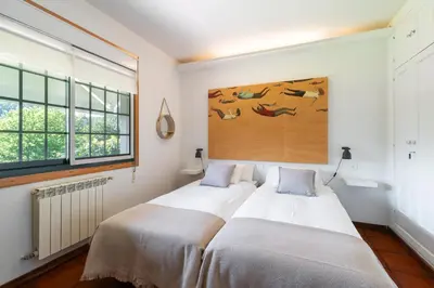 two beds in a bedroom with a painting on the wall at VILLA GUIMIL - GALICIA PLAYA in Villarmayor