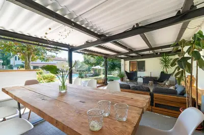 an outdoor dining room with a wooden table and chairs at VILLA GUIMIL - GALICIA PLAYA in Villarmayor